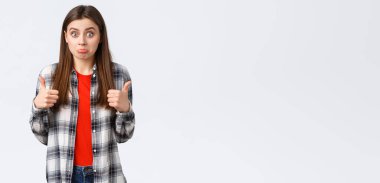 Yaşam tarzı, farklı duygular, boş zaman aktiviteleri konsepti. Fena değil sanırım. Güzel kız olumlu sonuç alınca şaşırdı, baş parmağını kaldırdı ve şaşkın bir ifade takındı, beyaz arka plandaydı..