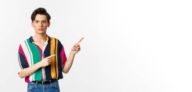 Genç yakışıklı adamın portresi sağ üst köşeyi işaret ediyor, logoyu gösteriyor, beyaz arka planın üzerinde duruyor..