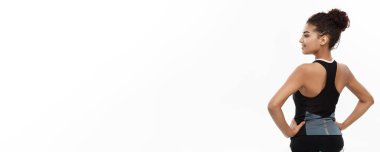 Sağlıklı ve Fitness kavramı - genç güzel Afrika kökenli Amerikalı onun sırt kas emin neşeli yüz ifadesi ile gösterilen portresi. Beyaz stüdyo arka plan üzerinde izole