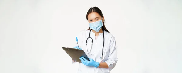 Lächelnde Asiatische Ärztin Mit Mundschutz Und Handschuhen Patientendiagnose Rezept Stift — Stockfoto