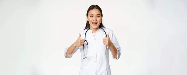 Šťastná Usměvavá Asijka Doktor Ukazující Palce Nahoru Souhlasu Spokojen Pacientem — Stock fotografie