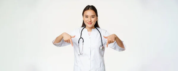 Jovem Asiática Médica Apontando Dedos Para Baixo Sorrindo Vestindo Estetoscópio — Fotografia de Stock