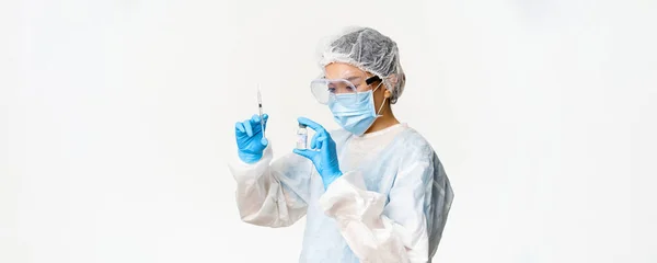 장비를 아시아 의사나 간호사 마스크와 백신으로 주사기를 채우고 환자들에게 실시하고 — 스톡 사진