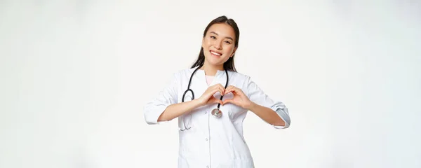 Usmívající Asijský Lékař Péče Své Pacienty Ukazuje Srdeční Gesto Vypadá — Stock fotografie