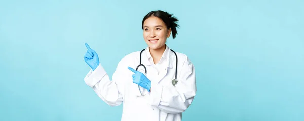 Asyalı Gülümseyen Doktor Sağlık Görevlisi Solu Işaret Eden Reklamlardan Memnun — Stok fotoğraf
