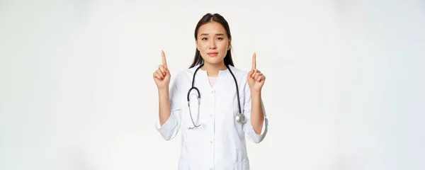 Усміхнена Азіатська Жінка Лікар Вказуючи Пальці Вгору Дивлячись Камеру Надає — стокове фото