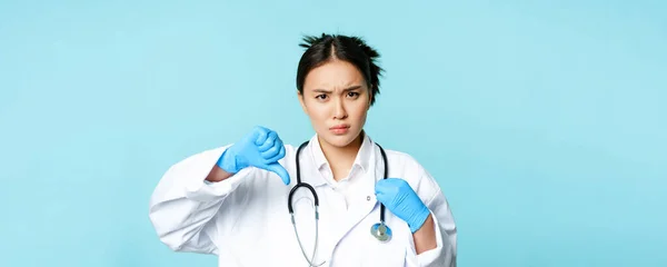 Rozzlobený Asijské Žena Lékař Lékař Uniformě Rukavice Ukazuje Palce Dolů — Stock fotografie