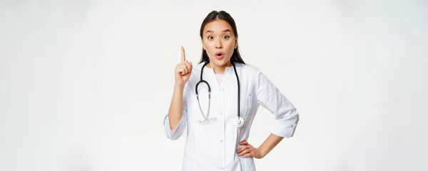 医療と医療の概念 指を上げるアジアの女性医師 解決策を見つけました 患者のための治療 指摘し 熱狂的に見て 白の背景 — ストック写真