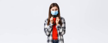 Coronavirus salgını, evden çalışma, online alışveriş ve temassız ödeme konsepti. Tıbbi maskeli neşeli güzel kadın kredi kartı ve göz kırpan küstah..