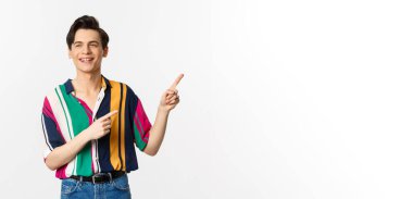 Tasasız adam şık gömlekli, sağ üst köşeyi işaret eden, reklam pankartı veya logosu gösteren, gülümseyen ve konuşan, beyaz arka planda duran biriyle konuşuyor..