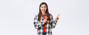 Yaşam tarzı, farklı duygular, boş zaman aktiviteleri konsepti. Heyecanlı kız, kontrolsüz tişörtünü giyer. Büyük meblağlardan bahseder, parmaklarını sağ üst köşeye uzatır, seninle konuşur, sevinir..