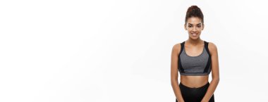 Sağlıklı ve Fitness konsepti. Spor için hazır spor elbiseli güzel Amerikalı Afrikalı bayan. Beyaz arkaplanda izole