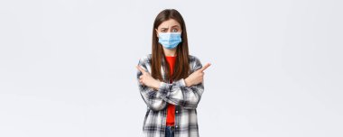 Coronavirus salgını, karantina, sosyal mesafeler ve duygu kavramı. Tıbbi maskeli, kararsız ve cahil güzel kız fikrini sor. Sağını solunu işaret eden tavsiyeler..