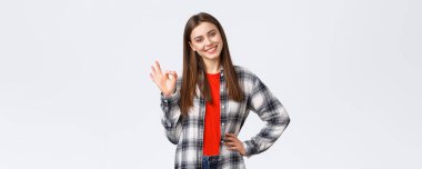 Yaşam tarzı, farklı duygular, boş zaman aktiviteleri konsepti. Kendine güvenen genç bir kadın sorun yok diyor, kalite garantisi veriyor, işaret veriyor, başını eğ ve gülümse..