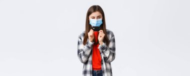 Coronavirus salgını, evden çalışma, online alışveriş ve temassız ödeme konsepti. Tıbbi maskeli neşeli güzel kadın kredi kartı ve göz kırpan küstah..