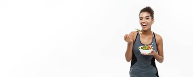 Sağlıklı ve Fitness kavramı - taze salata yemek diyet fitness giysili güzel Amerikan Afrika Bayan. Beyaz arka plan üzerinde izole