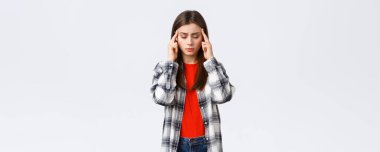 Yaşam tarzı, farklı duygular, boş zaman aktiviteleri konsepti. Odaklanmaya çalışan üzgün ve yorgun genç kız öğrenci baş ağrısı ya da baş dönmesi hisset, gözlerini kapat ve tapınakları ovala, beyaz arka plan.