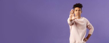 Orada dur, uzak dur. Yaklaşma. Ciddi görünümlü, sağlıklı, İspanyol bir gencin portresi kötü bir şeyi önlemeye çalışıyor, uyarı hareketi yapıyor, yasaklıyor ya da yasaklıyor..