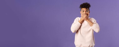 Etkilenmiş İspanyol bir gencin portresi dedikoduyu öğrendi, dedikoduları duydu, gülmemeye çalıştı elleri ile ağzını kapattı ve şaşkınlığını dile getirdi ve bakışlarıyla şaşırdı, mor arka plan.