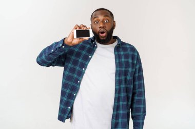 Yakışıklı afro-amerikan adam gri arka plan izole, akıllı telefon sunan