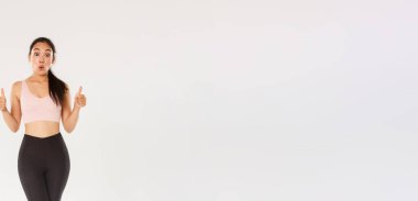 Aktif giyimde tam uzunlukta hayran ve etkilenmiş bayan sporcu, onaylama ve merak gösterme, harika egzersiz programı, fitness eğitim uygulaması veya spor salonu üyelik fiyatları övgü.