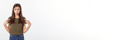 Güzel, genç, zarif bir kadın, izole bir arka planda, elleri ve parmakları üzgün bir ifadeyle işaret ediyor.