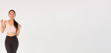 Spor, spor salonu ve sağlıklı vücut konsepti. Tam uzunlukta teşvik edilmiş ve motive olmuş Asyalı esmer kız fitness antrenmanına, yumruk tokuşturmaya ve sevinçle bağırmaya hazır ol, antrenman uygulaması ile amacına ulaş.