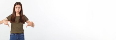 Güzel, genç, zarif bir kadın, izole bir arka planda, elleri ve parmakları üzgün bir ifadeyle işaret ediyor.