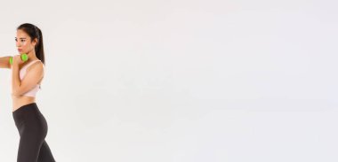 Spor, spor salonu ve sağlıklı vücut konsepti. Tam boy kadın sporcu, spor yapan Asyalı esmer kız, dambıllarla egzersiz, beyaz arka planda verimli bir beden eğitimi..