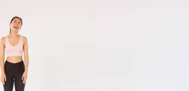 Spor, spor salonu ve sağlıklı vücut konsepti. İsteksiz ve mızmız Asyalı tatlı esmer kız antrenmana gitmek istemiyor, ağlıyor ve şikayet ediyor. Spor yaptıktan sonra kendini yorgun hissediyor..