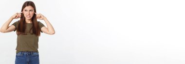 Kulaklarını tıkayan kızgın genç bir kadının yakın plan portresi, şu gürültüyü kes. Başımı ağrıtıyor, beyaz arka planda izole edilmiş.