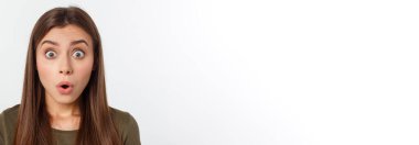 Şaşırmış ve ağzı açık bir şekilde kafasını tutan güzel bir kızın yakın plan portresi. Beyaz arkaplan.