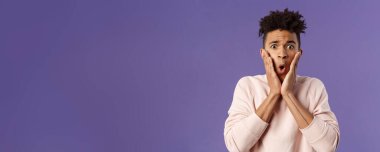 Endişeli, mahcup olmuş genç adamın yakın plan portresi. Yanaklarından tutunun. Umutsuz ve telaşlı görünüyor..