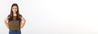 Gri arka planda yalnız duran mutlu ve şaşırmış genç bir bayan portresi. Kamera işaret ediyor