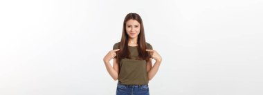 Gri arka planda yalnız duran mutlu ve şaşırmış genç bir bayan portresi. Kamera işaret ediyor