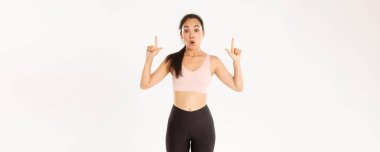 Spor, refah ve aktif yaşam tarzı konsepti. Etkilenmiş ve meraklı Asyalı bayan sporcu hayret verici görünüyor ve parmaklarını havaya kaldırıyor, indirimi ve özel teklifleri bilmek istiyor..