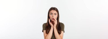 Şaşırmış ve ağzı açık bir şekilde kafasını tutan güzel bir kızın yakın plan portresi. Beyaz arkaplan.