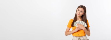 Gri arka planda tek başına duran mutlu genç bir kadının fotoğrafı. Para ve kredi kartını bir kenara bırakarak.