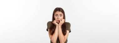 Şaşırmış ve ağzı açık bir şekilde kafasını tutan güzel bir kızın yakın plan portresi. Beyaz arkaplan.