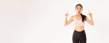 Spor, refah ve aktif yaşam tarzı konsepti. Etkilenmiş ve meraklı Asyalı bayan sporcu hayret verici görünüyor ve parmaklarını havaya kaldırıyor, indirimi ve özel teklifleri bilmek istiyor..