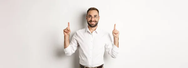 Zelfverzekerde Knappe Zakenman Met Logo Wijzend Omhoog Kijkend Naar Aankondiging — Stockfoto