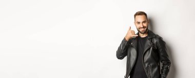 Deri ceketli yakışıklı adam seninle flört ediyor, bana jest yapıyor, beyaz arka planda duruyor..