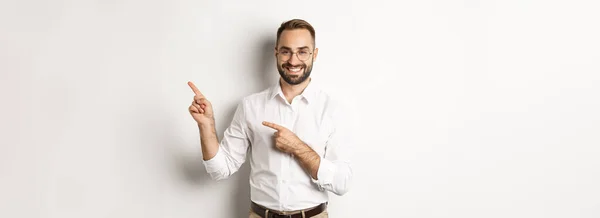 Komea Menestyvä Liikemies Osoittaa Sormella Oikealle Näyttää Mainoksen Tyytyväinen Kasvot — kuvapankkivalokuva