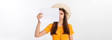 Kafkasyalı genç bir kadın, elinde boş bir kâğıt çarşaf ile izole edilmiş bir arkaplanı tutuyor. Şok olmuş, korkmuş ve heyecanlı bir yüz ifadesi var.