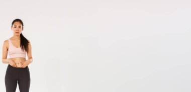 Uzun, üzgün ve kasvetli bir Asyalı kız, göbeğini gösteriyor, vücudunu şikayet ediyor, somurtuyor ve hayal kırıklığına uğramış görünüyor, spor yapmaya başlıyor, kilo vermeye çalışıyor, beyaz bir altyapısı var..