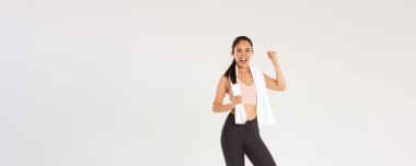 Spor, spor salonu ve sağlıklı vücut konsepti. Tam uzunlukta teşvik edilmiş ve motive olmuş Asyalı esmer kız fitness antrenmanına, yumruk tokuşturmaya ve sevinçle bağırmaya hazır ol, antrenman uygulaması ile amacına ulaş.