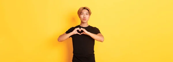 Portrét Půvabného Pohledného Blonďatého Asiata Ukazující Gesto Srdce Úsměv Stojící — Stock fotografie