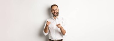 Tatmin olmuş iş adamı kamerayı işaret ediyor, seni övüyor, onaylıyor ya da başka bir şey yapıyor, beyaz arka plan..