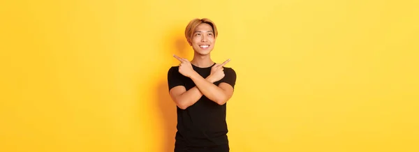 Portrait Smiling Pleased Asian Guy Looking Left Making Decision Pointing — Stock Photo, Image