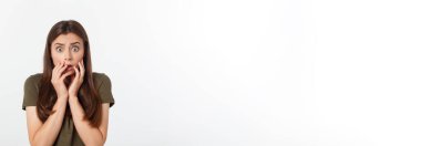 Şaşırmış ve ağzı açık bir şekilde kafasını tutan güzel bir kızın yakın plan portresi. Beyaz arkaplan.